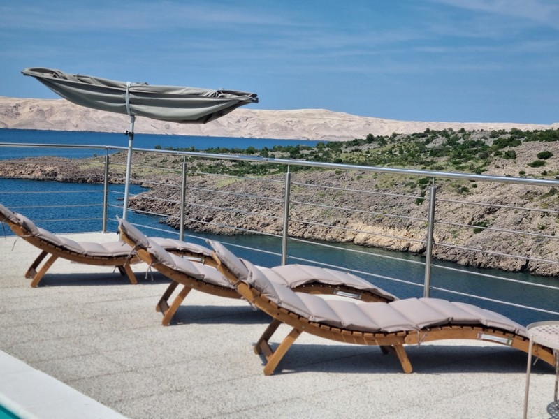 Sdraio con ombrellone e vista mare sulla terrazza