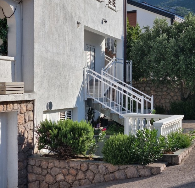 Vista esterna della casa plurifamiliare con scala e giardino
