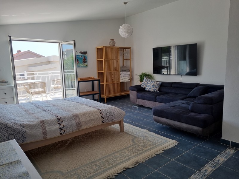 Monolocale con letto, divano e accesso alla terrazza