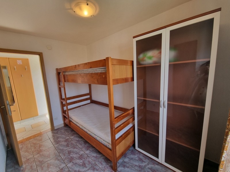 Cameretta con letto a castello in legno e vetrina