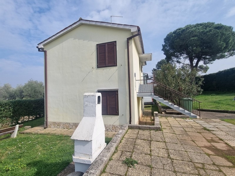 Timpano della casa con persiane e cortile lastricato