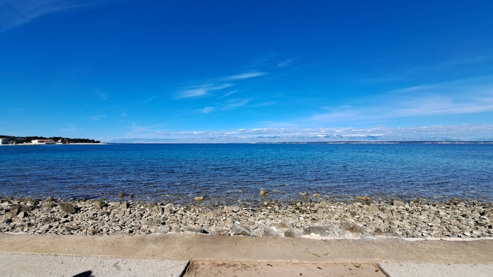 Spiaggia di ciottoli e mare limpido davanti a un immobile sul mare in Croazia