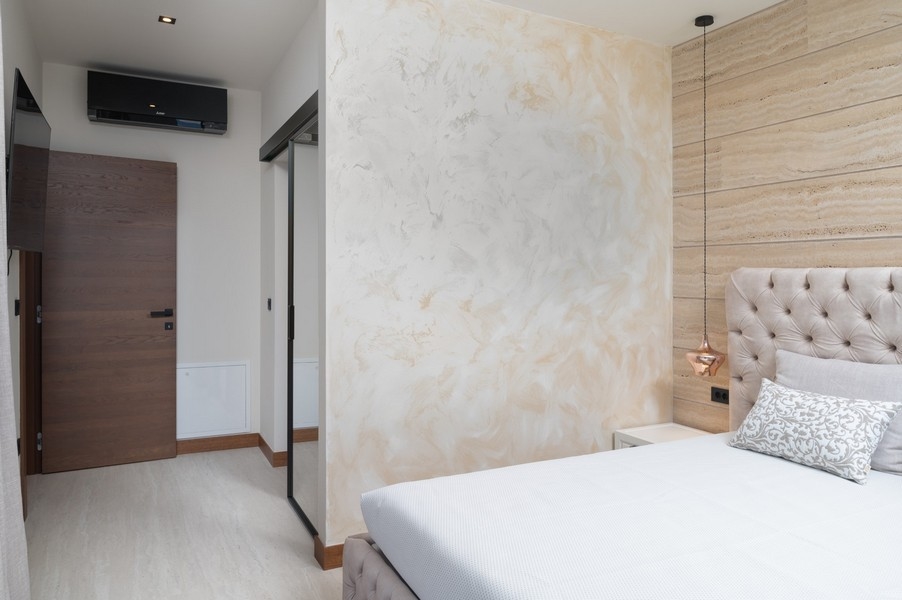 Camera da letto di design moderno con testiera imbottita in una villa in vendita a Razanac, zona di Zadar, Croazia, con porta scorrevole sul corridoio