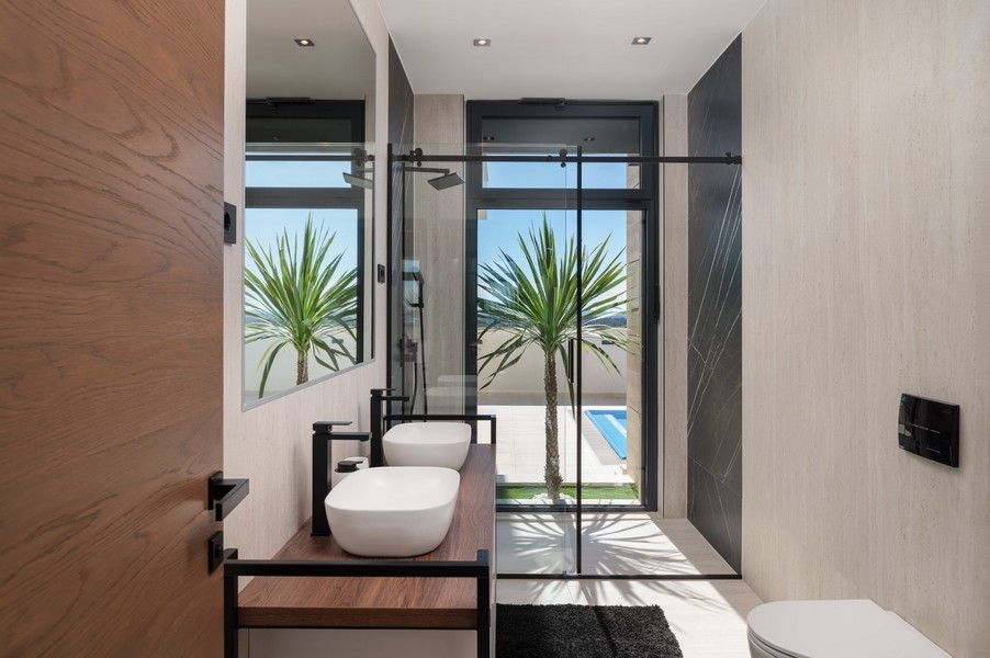 Bagno di lusso con doppio lavabo in una villa in vendita a Razanac, zona di Zadar, Croazia, con vista diretta sulla piscina e sul panorama del mare.
