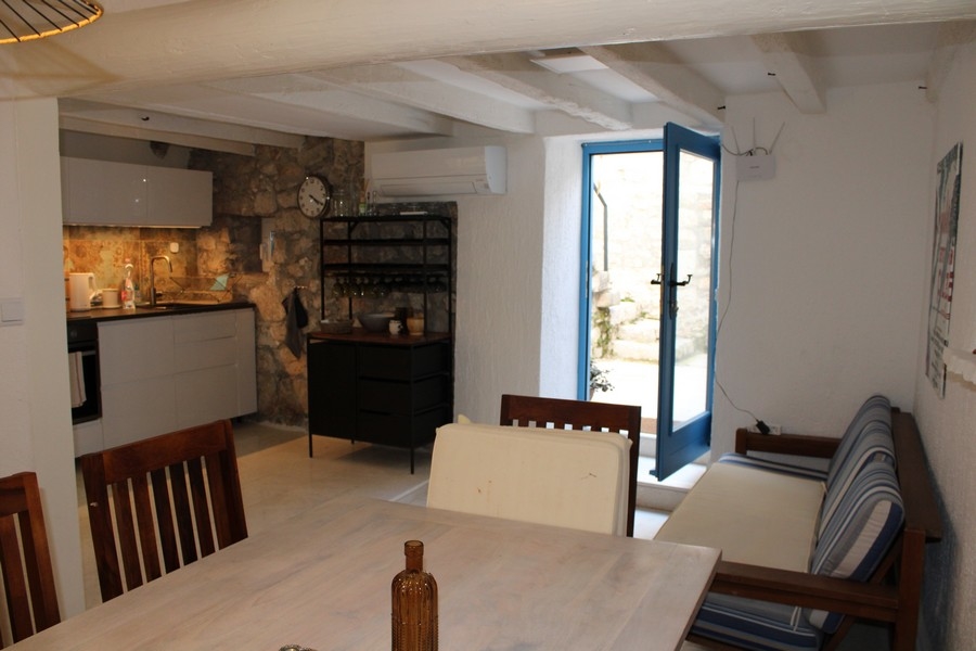 Vista interna della casa in pietra a Murter, soggiorno e zona pranzo.