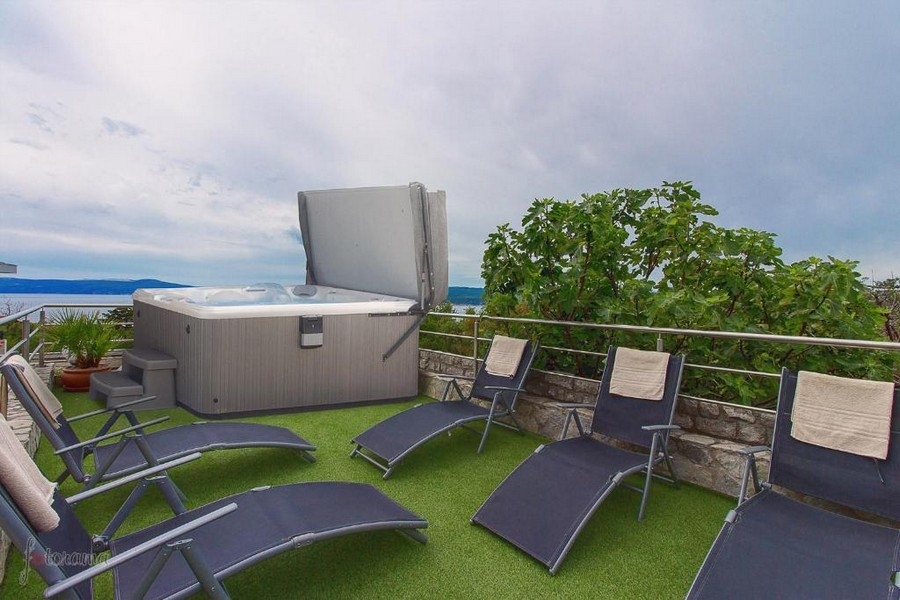 Terrazza sul tetto con vasca idromassaggio e sedie a sdraio, immobile in Croazia con vista sul mare