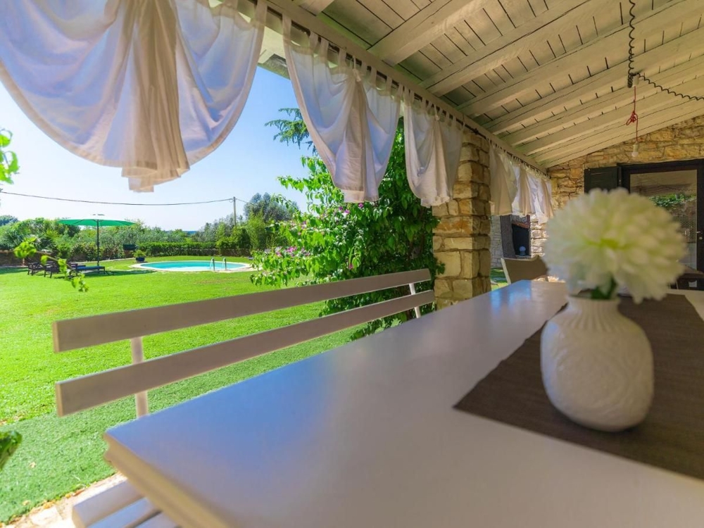 Veranda coperta con vista sulla piscina e sul prato curato, una caratteristica degli immobili in Croazia
