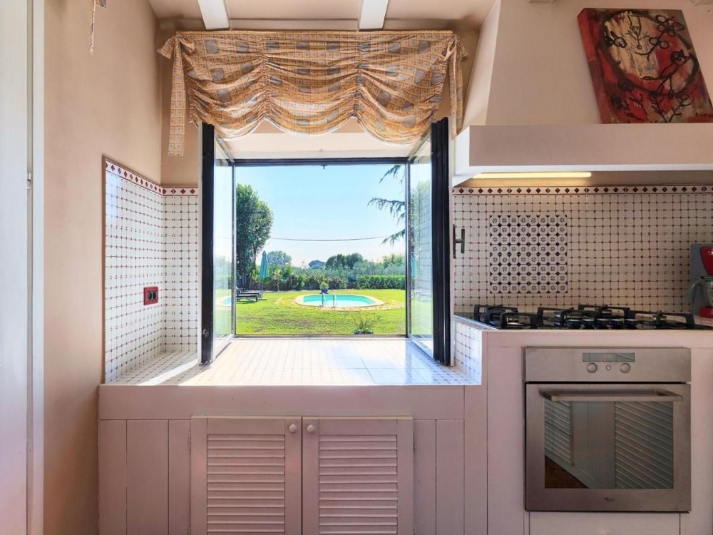 Finestra della cucina con vista sulla piscina e sul giardino, un punto forte tra gli immobili in Croazia