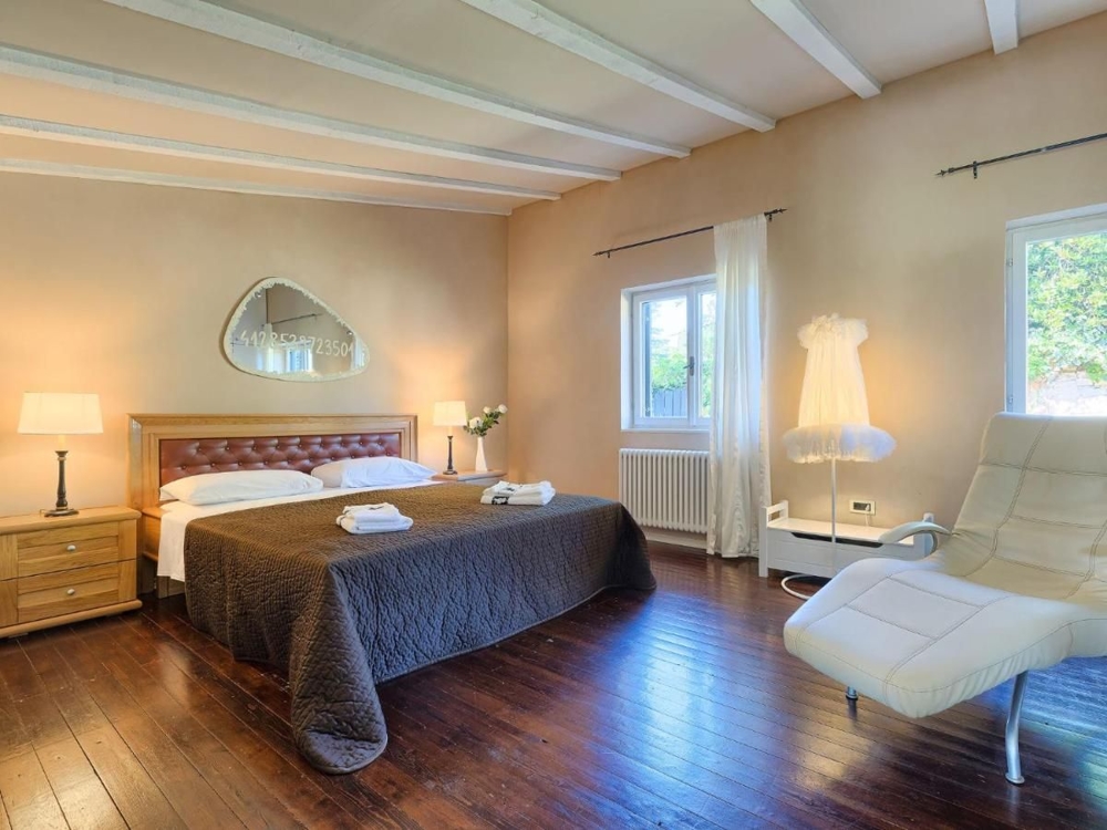 Grande camera da letto con pavimento in legno e comfort moderno, un aspetto degli immobili di lusso in Croazia