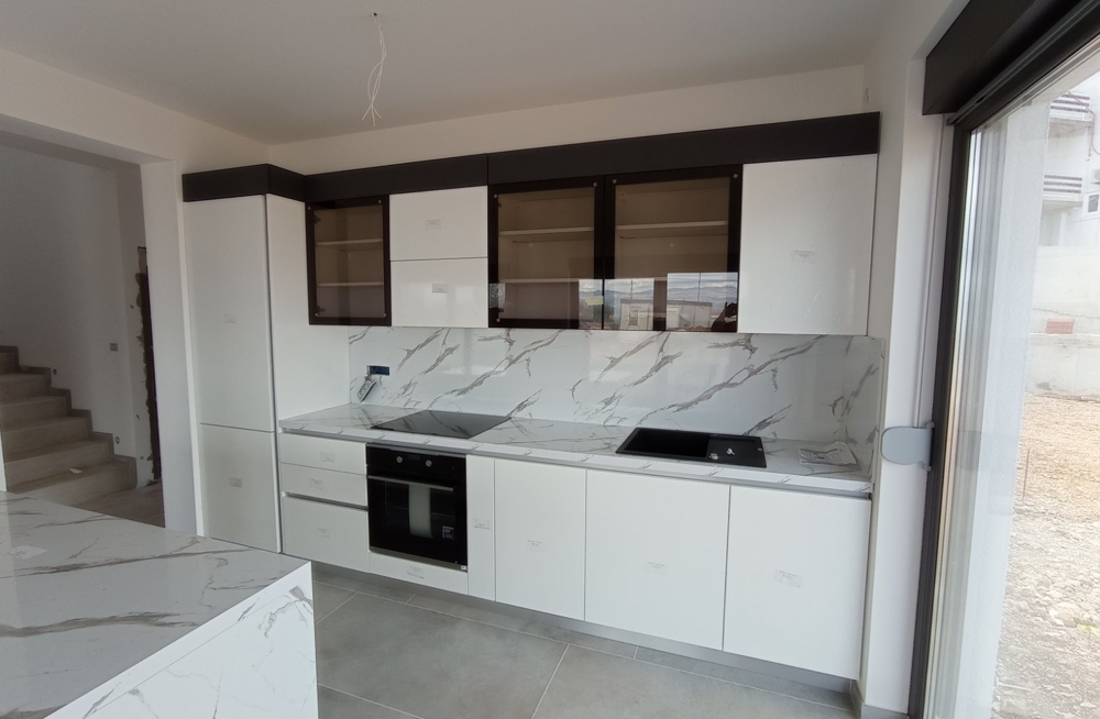 Vista interna di una cucina moderna con mobili bianchi in un immobile in Croazia.