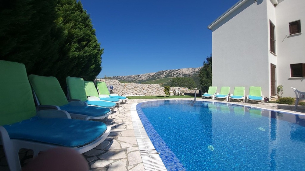 Piscina con lettini accanto alla casa