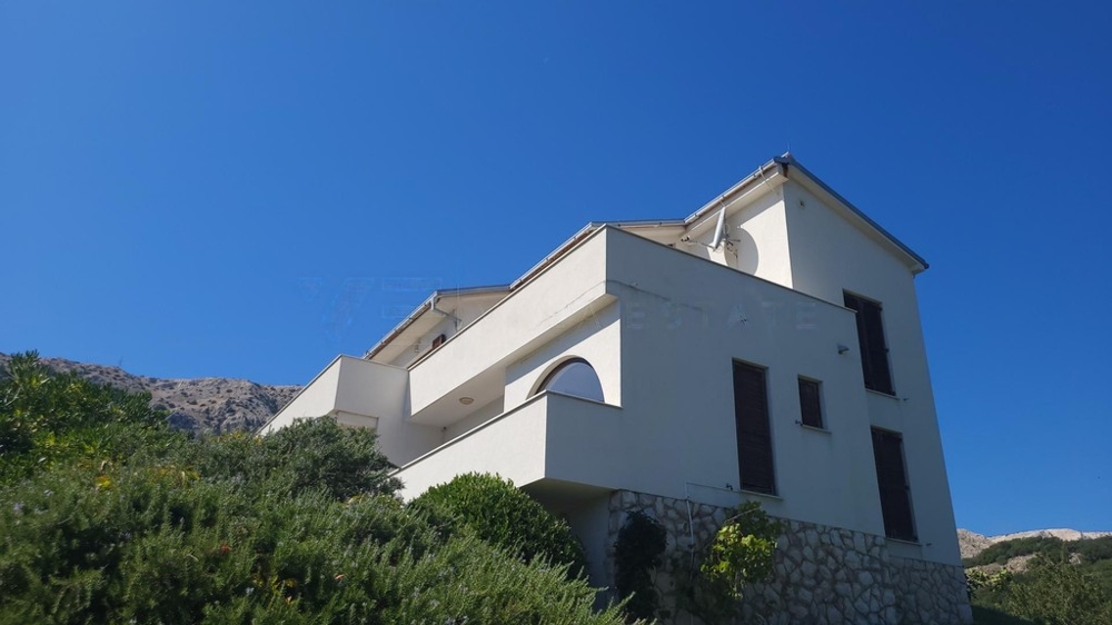 Facciata bianca della casa con balconi sul pendio