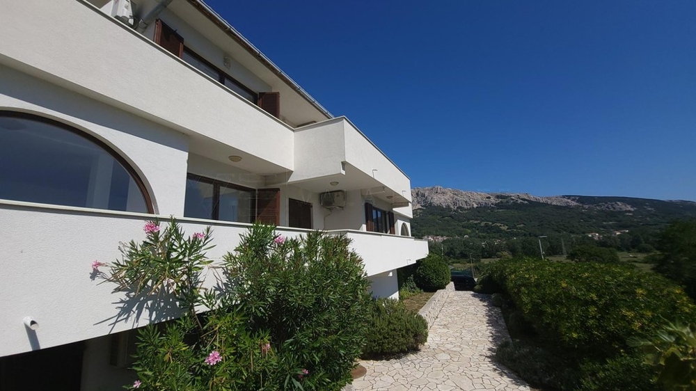 Vista della casa con balconi e oleandro in fiore