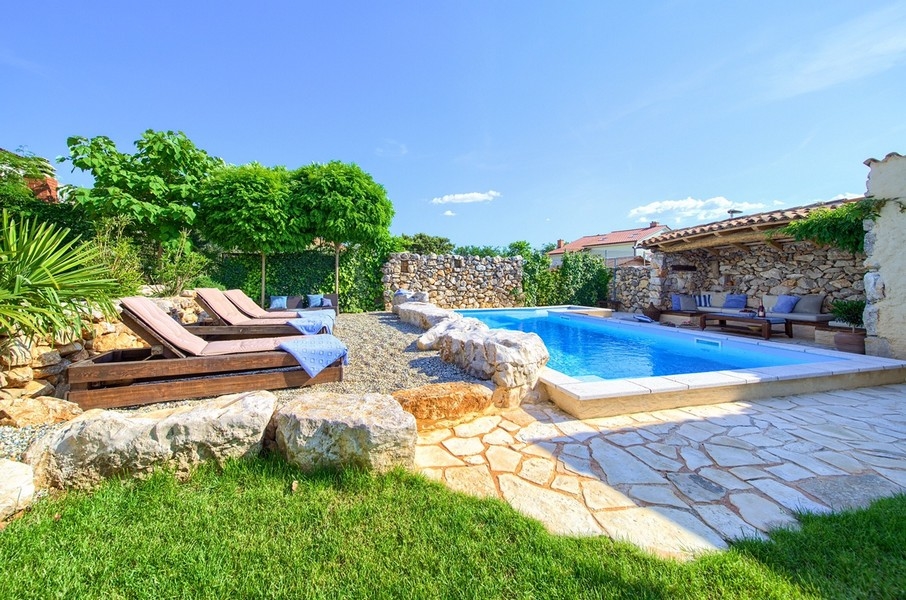 Giardino curato con piscina e sdraio, parte dell'offerta dell'immobile sull'isola di Krk.