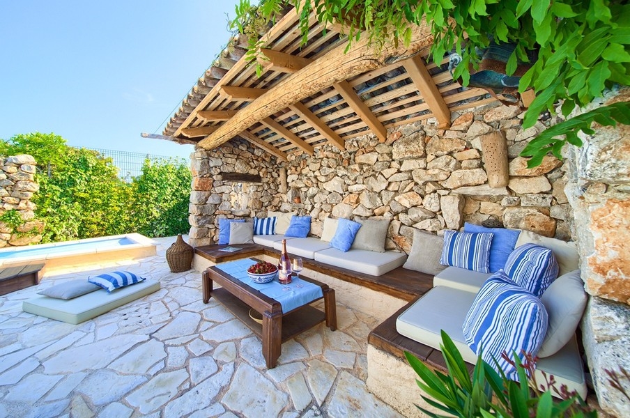 Zona relax esterna coperta con comodi cuscini e vista sulla piscina, tipica dell'immobile sull'isola di Krk.