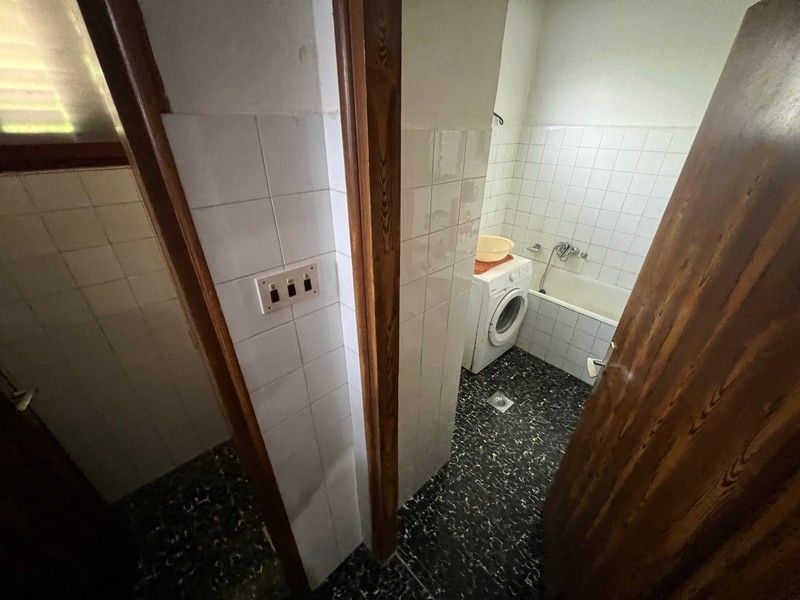 Semplice bagno con lavatrice e WC, mostra le dotazioni di un immobile sull'isola di Krk.