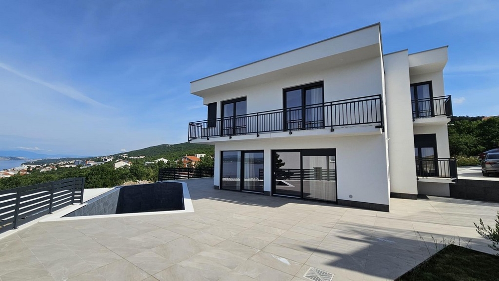 Casa bianca con ringhiere nere ai balconi e vasche della piscina