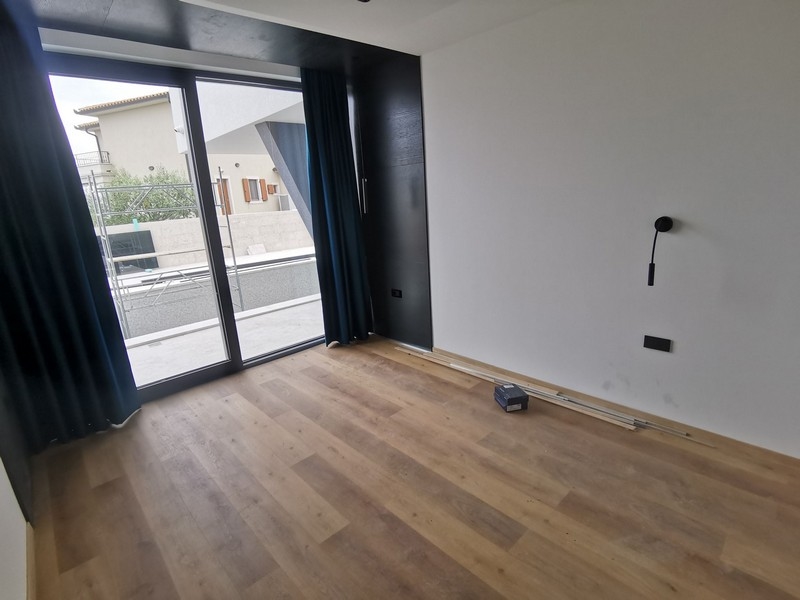 Stanza con parquet e porta in vetro sul balcone