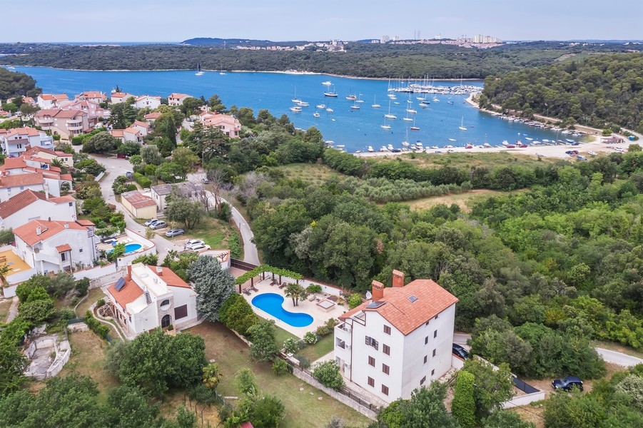 Immobili Croazia, casa plurifamiliare in Istria con vista mare - Panorama Scouting H3025: una ripresa aerea mostra una pittoresca cittadina costiera con diverse case e barche in acqua