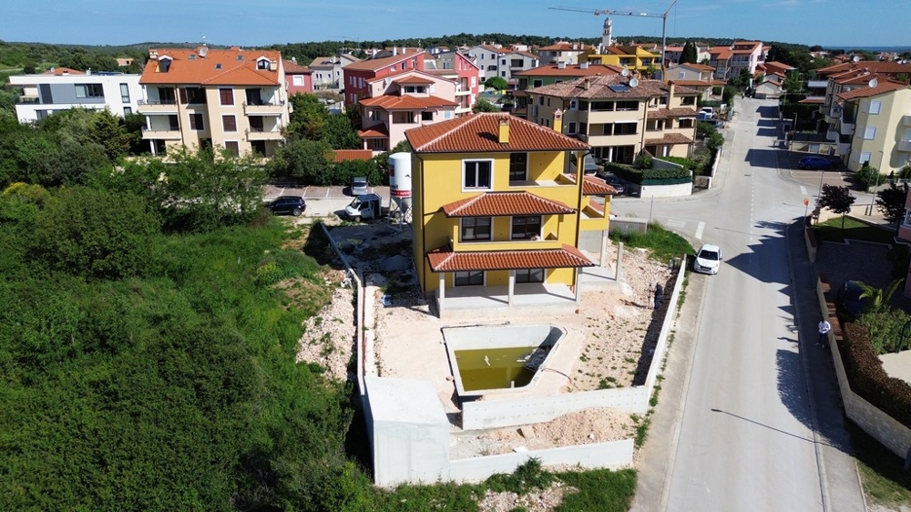 Ampia villa in Croazia durante la fase di costruzione, circondata da case moderne e aree verdi