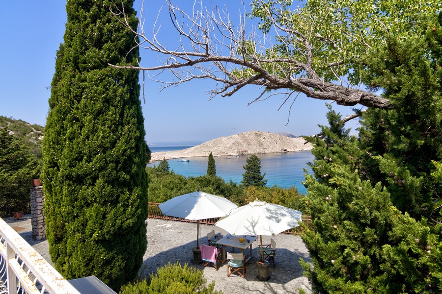 Ombrelloni in giardino con vista tra i cipressi sulla baia