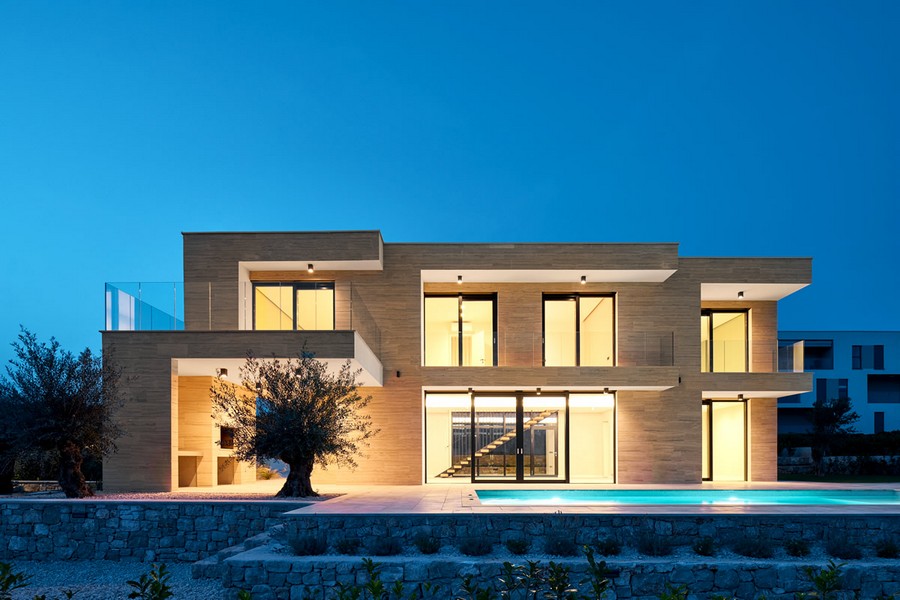 Villa illuminata con ulivo e piscina all'ora blu