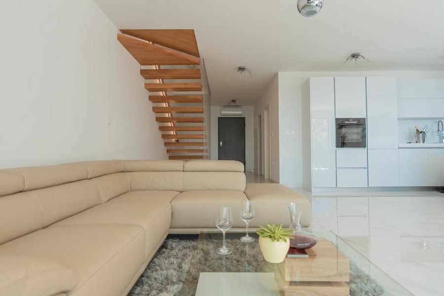 Elegante soggiorno con cucina a vista e scala