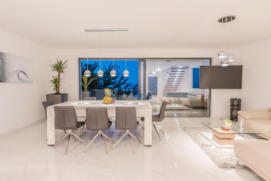 Elegante zona pranzo con mobili moderni e illuminazione serale