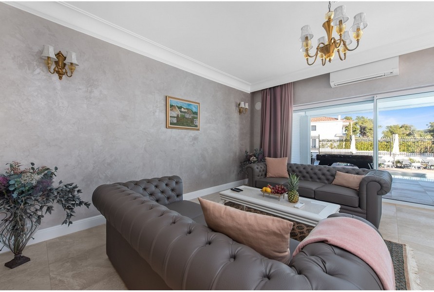 Elegante soggiorno della villa H3042 con comodi divani e vista sull'area esterna