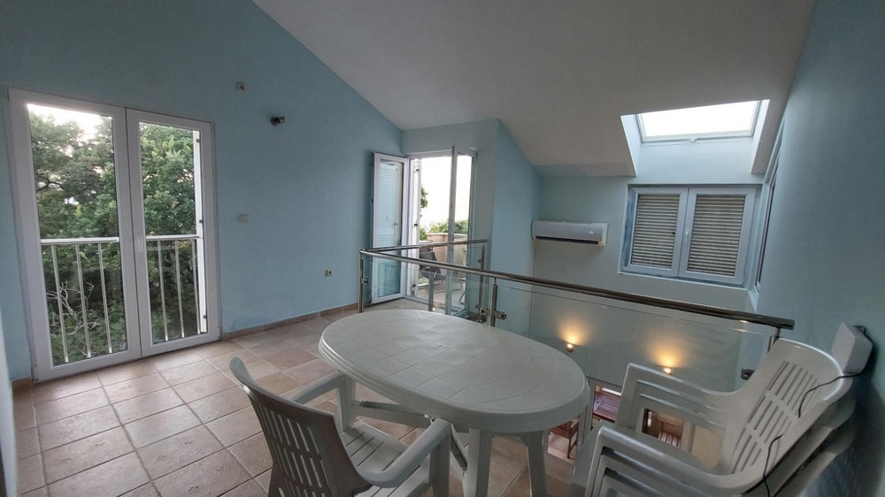 Galleria con tavolo, sedie e accesso a due balconi in una casa in Croazia