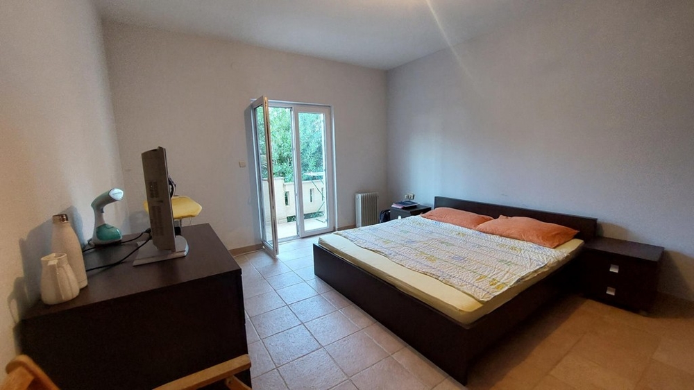 Camera da letto con letto matrimoniale e accesso al balcone in una casa in Croazia