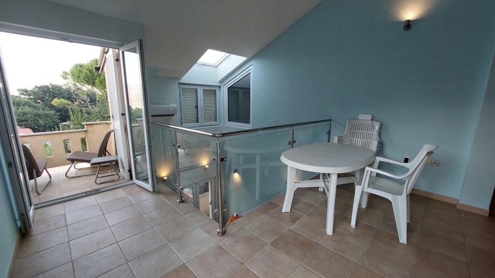 Galleria con tavolo e sedie che conduce a un balcone in una casa in Croazia