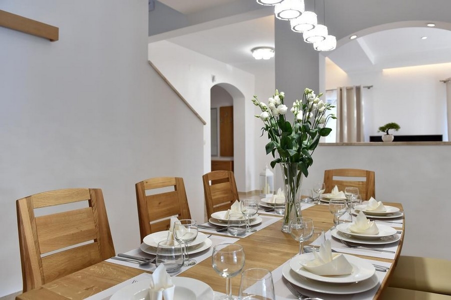 Elegante zona pranzo con tavola apparecchiata e composizione floreale