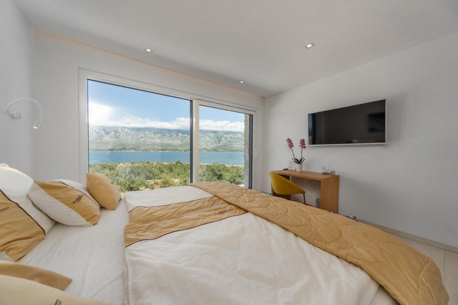 Camera da letto con finestra panoramica e vista mare