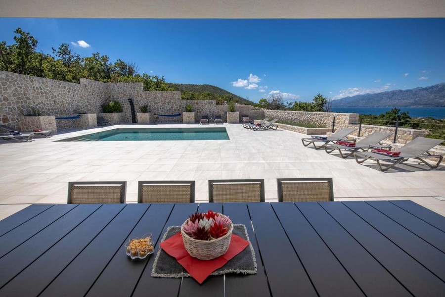 Terrazza con piscina e lettini prendisole