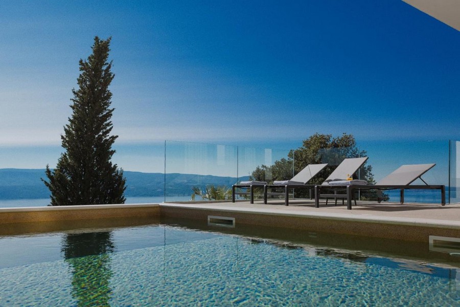 Piscina con cipresso e lettini davanti all'ampia vista sul mare