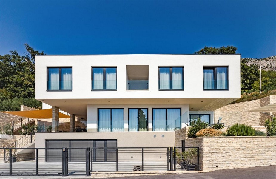 Villa bianca con tendone e muro a secco sul pendio