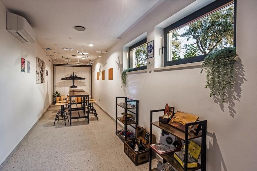 Stanza hobby con aeromodelli appesi al soffitto e scaffali alla parete
