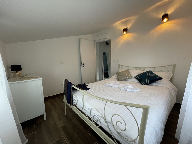 Camera da letto con letto bianco in ferro battuto, cuscini decorativi e ambiente moderno