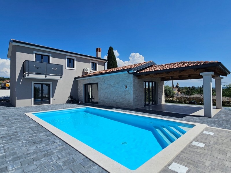 Casa con parete in pietra naturale e pergola accanto alla piscina