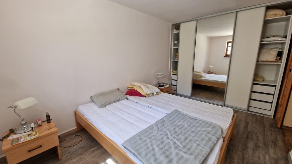 Camera da letto con letto matrimoniale, grande armadio e arredamento minimalista.