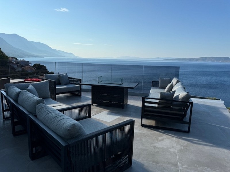 Lounge con tavolo con fuoco sulla terrazza sopra la baia