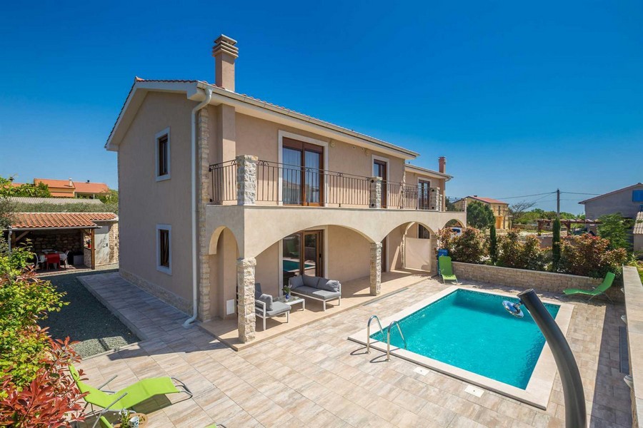 Casa con arcate e balcone accanto alla piscina