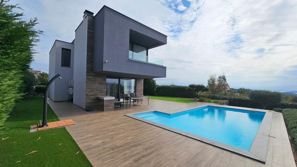 Villa moderna con piscina e deck in legno nel giardino