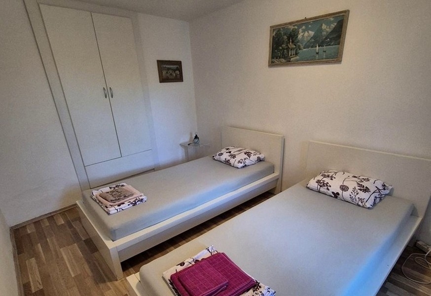 Camera da letto con due letti singoli e mobili semplici.
