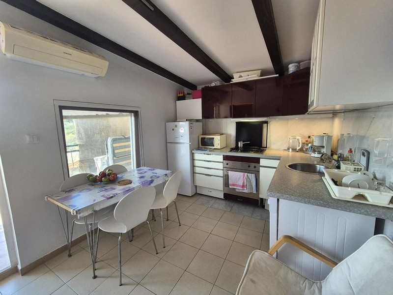 Cucina moderna con zona pranzo e aria condizionata al primo piano.