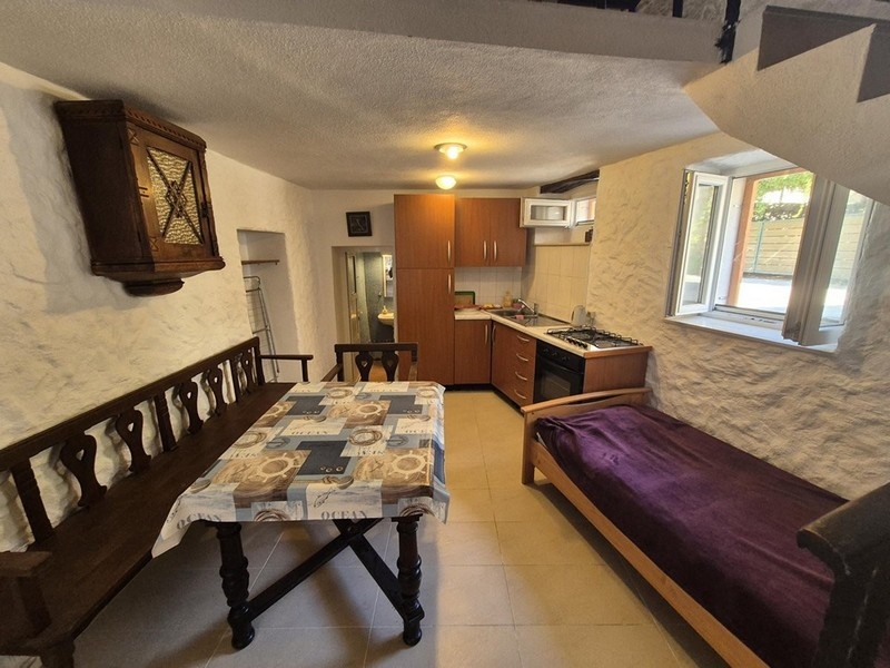 Zona pranzo e cucina con arredamento rustico al piano terra della casa.