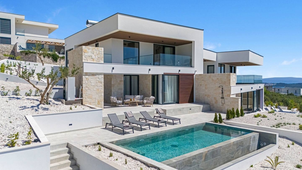 Villa con fasce in pietra naturale e piscina nel giardino di ghiaia