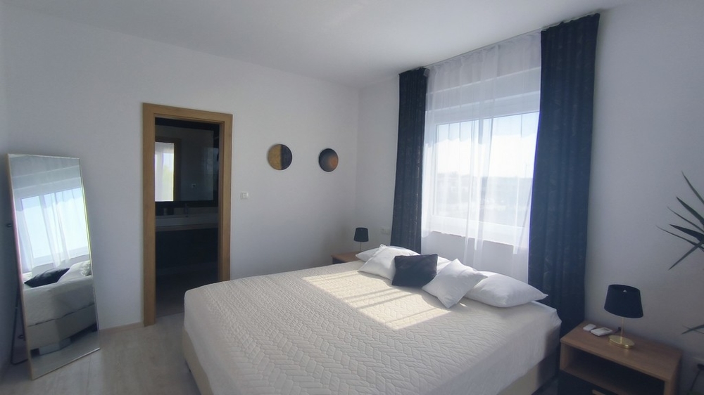 Seconda camera da letto con grande letto e bagno adiacente.