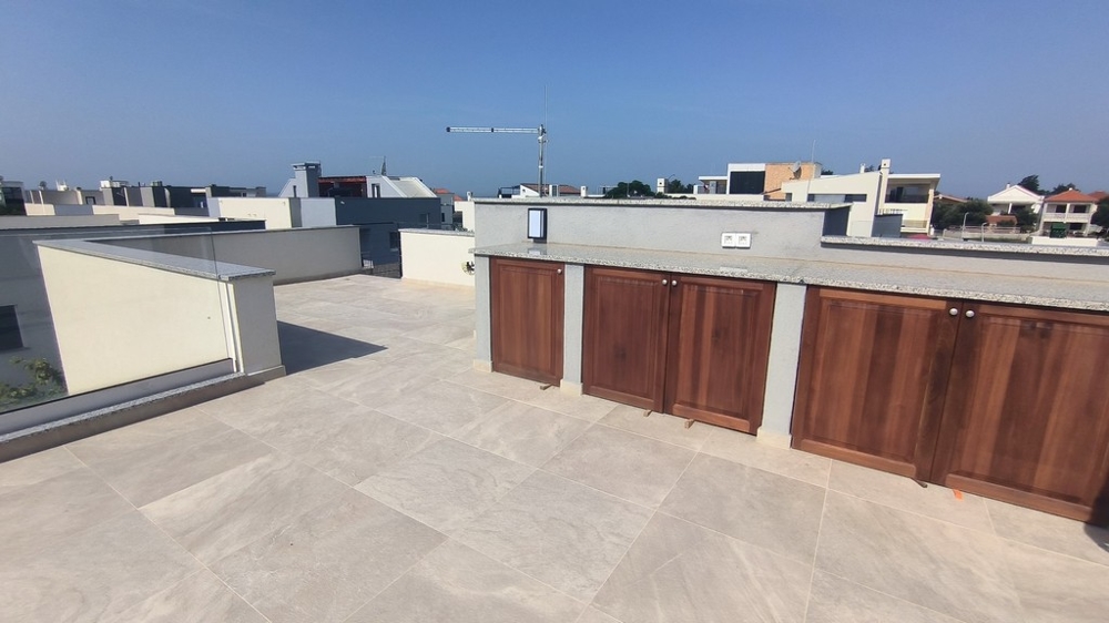 Spaziosa terrazza sul tetto con mobili in legno incassati.